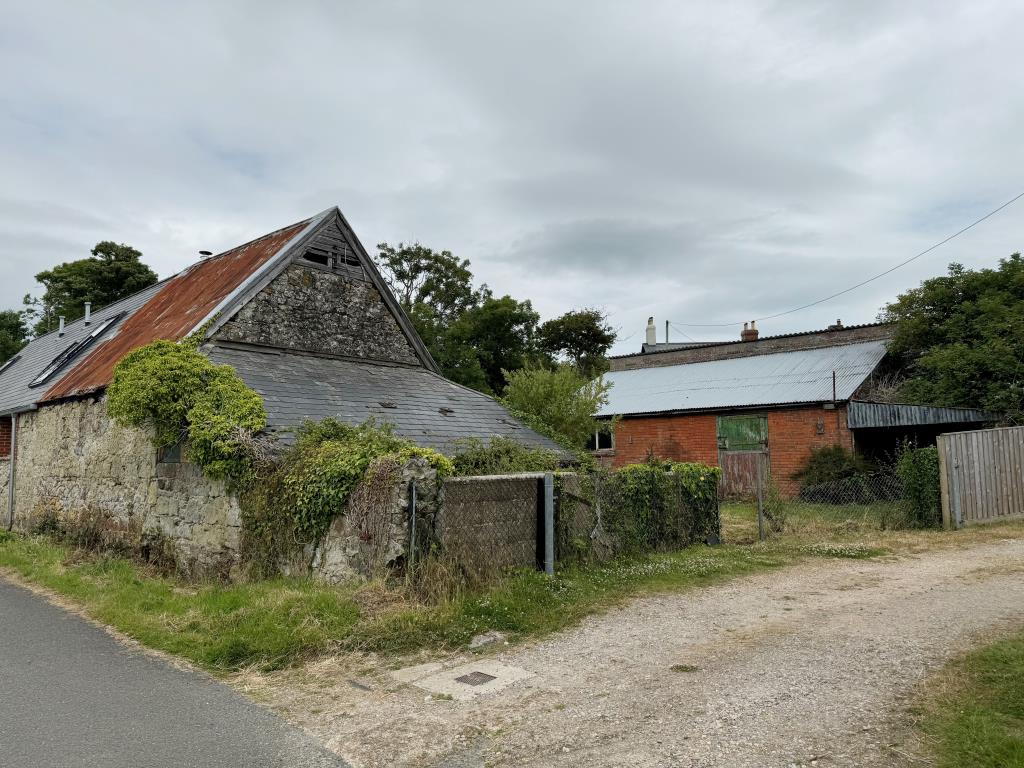 Lot: 49 - TWO FREEHOLD BARNS WITH CONSENT FOR RESIDENTIAL CONVERSION - A view of both barns from the lane